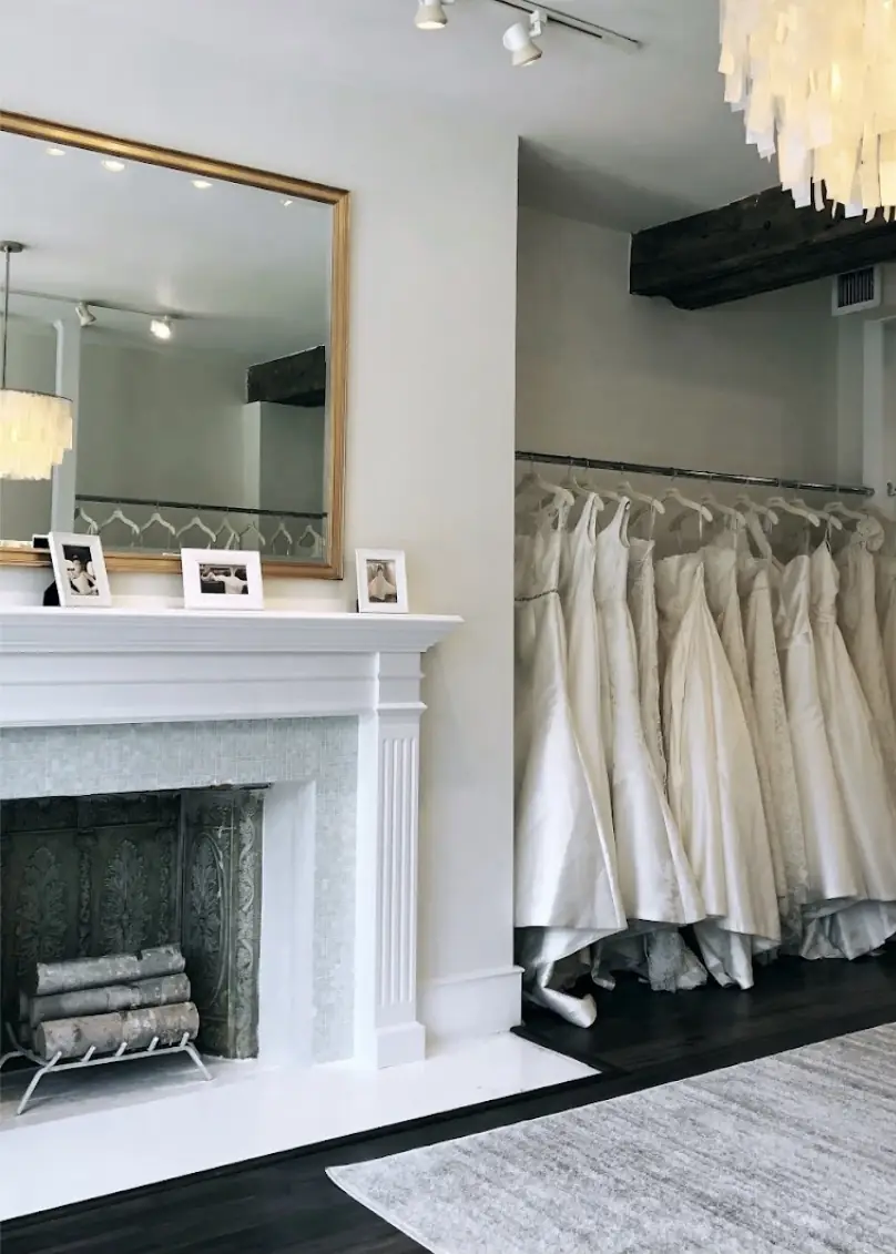 Inside the Modern Trousseau flagship salon in Georgetown, gowns hanging beside the fireplace
